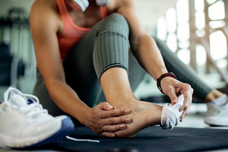 During her workout, a woman removes her shoes and socks to examine her foot for athlete's foot